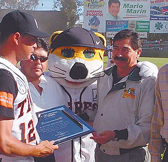 Homenajeado Hernández izq recibe la placa de reconocimiento